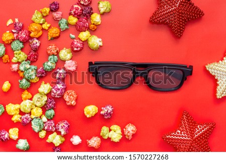 Holiday Movies. Cinemas, movie times concept. Popcorn mix, 3d glasses, christmas stars on red background.