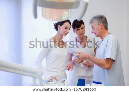 Dentist talking with hygienists in dentist's office