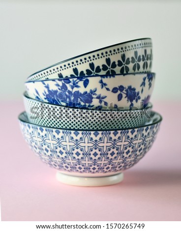 Four designer ceramic bowls in white and blue colors stacked together