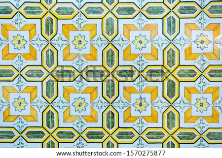 Traditional Portuguese azuleju tile with floral ornament of white, yellow and green color.
