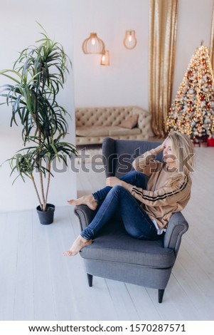 New year photo session of a young girl. Attractive blonde. A cozy atmosphere in the studio.