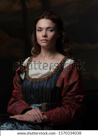 Portrait of a young woman in the style of a Renaissance painting. Beautiful mysterious girl in medieval dress Royalty-Free Stock Photo #1570334038