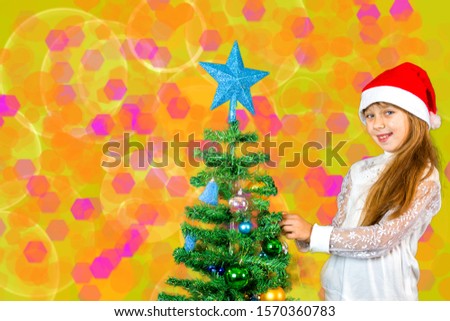 little girl decorates a Christmas tree, abstract background