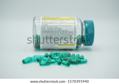 Ibuprofen gel tabs spilled in a pile with a bottle in the background