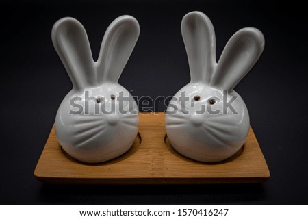 Pepper and salt shaker in the form of hares on a wooden stand