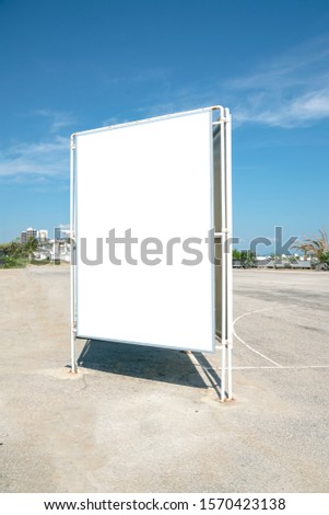 large big blank white display billboard standing on asphalt road at city street, mock-up