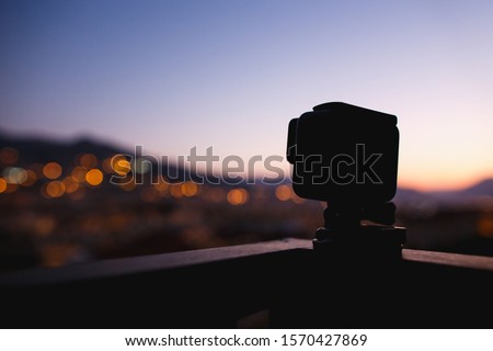 Taking timelaps video on action camera on sunset or sunrise. Mountains, dusk.