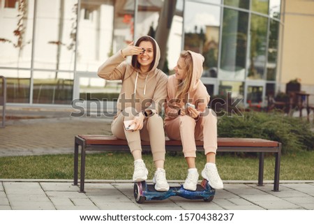 Women in a autumn park. Girl in a brown suits. Friends have fun with giroboard