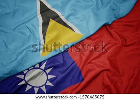 waving colorful flag of taiwan and national flag of saint lucia. macro
