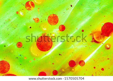 Oil drops on a water surface. Pink and lilac background.