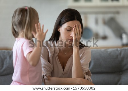 Tired single mother feel stressed desperate about screaming stubborn kid daughter tantrum, frustrated depressed young adult mom annoyed by naughty difficult rebellious child girl problems concept Royalty-Free Stock Photo #1570550302