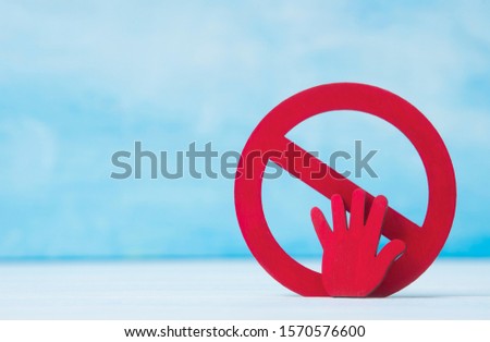 Red forbidden sign and hand  on blue background. Coronavirus concept