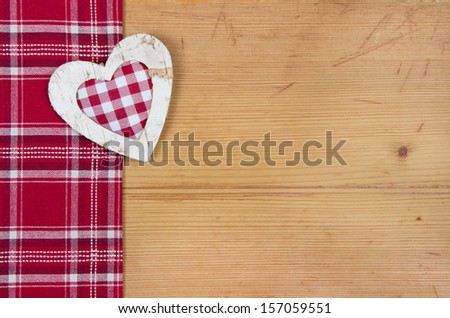 Christmas : Red and white fabric with checked heart on wooden background 
