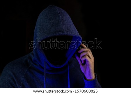 The hacker is calling.  A fraudster is holding a telephone in his hand. Royalty-Free Stock Photo #1570600825