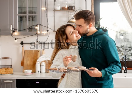 young married couple baking cookies in the kitchen Royalty-Free Stock Photo #1570603570