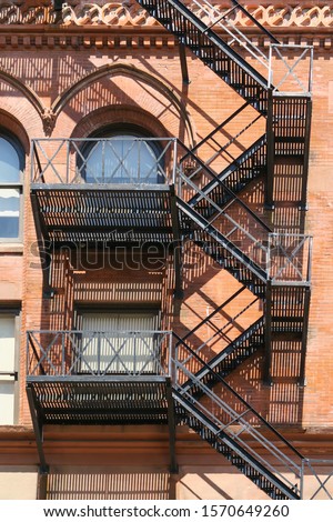 Metallic fire escape on the red bricks wall of the Gooderham building in Toronto 