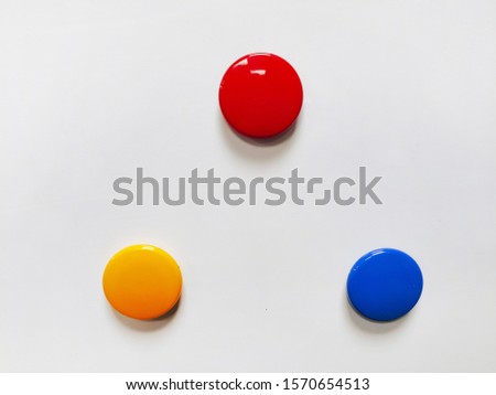 Round colored magnetic markers pinned to a white board with copy space