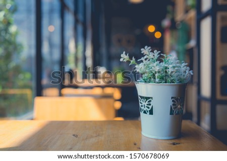 Vintage picture tone of Artificial plants plastic tree on table for decoration and welcome feeling fresh for customers in coffee shop. Backdrop space for text or art work design.