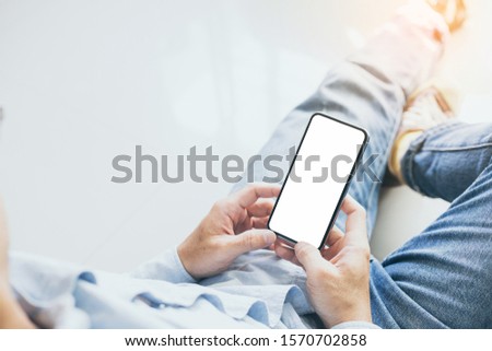 Mockup image blank white screen cell phone.men hand holding texting using mobile 
at home.background empty space for advertise text.people contact marketing business and technology 