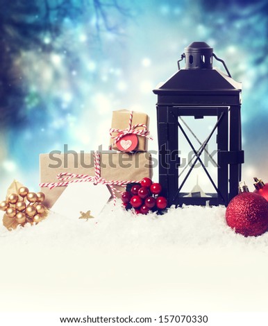 Christmas lantern with ornaments in the snow at night