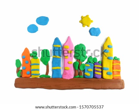 The city with fresh air is made from colorful clay plasticine on white background, many tall buildings and trees beneath the bright sky are beautiful town dough