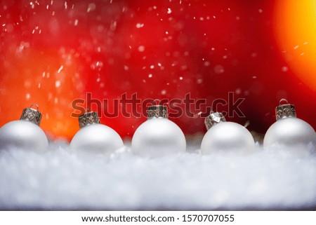 New Year and Christmas background. White Christmas toys lie in the snow, with a bright background. Falling snow. Christmas discounts and sales.