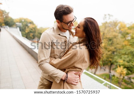 Outdoor  photo of happy young woman with her boyfriend enjoying date. Cold season. 
