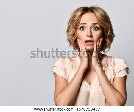 excited screaming shocked beautiful woman standing in satin blouse isolated on a light background.