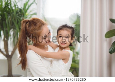Happy loving family.Asian mother and child girl playing, kissing and hugging