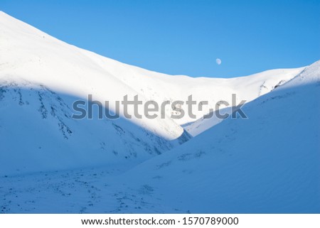Mountain covered by snow with moon in the sky