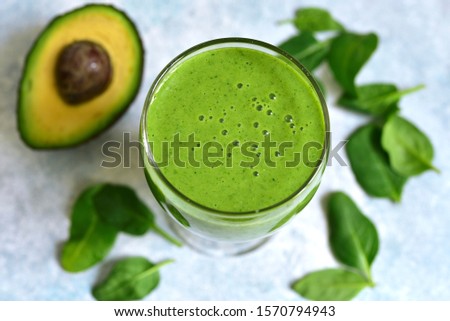Detox green smoothie with apple, avocado and spinach on a light blue slate, stone or concrete background. Top view with copy space.