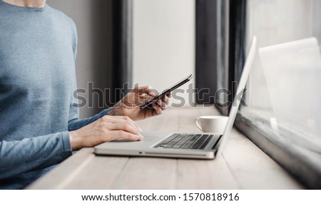 Businessman working on computer. Men using smart phone and laptop in the office. Internet marketing, finance, business concept