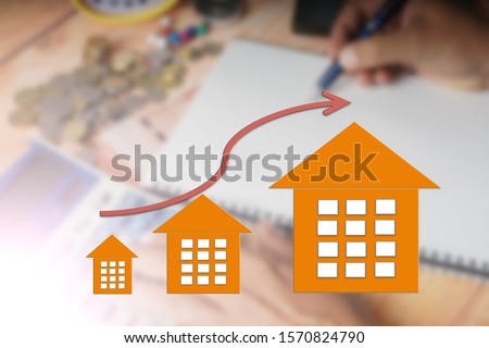 Property up trend market conceptual with up trend arrow and house icon. Blurred image background.
