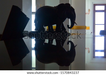 Wooden sculpture of an elephant on a black polished table