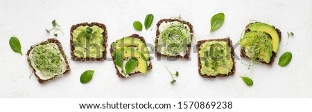 Dietary fitness toast with avocado, tofu cheese and microgreen, isolated on white, top view, panorama Royalty-Free Stock Photo #1570869238