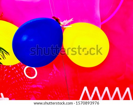 Yellow and blue balloon hanging on a red wall preparing for party, Merry Christmas and Happy New Year festivals