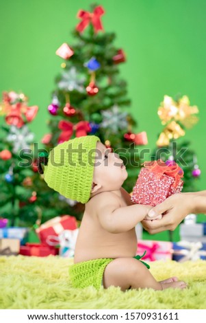 Cute little baby with gift celebrates Christmas.New Year's holidays