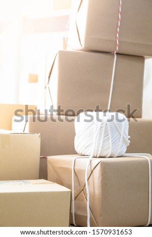 Stack of boxes wrapped in rustic paper and tide with rope.