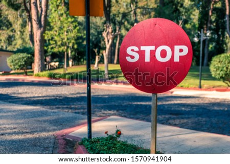 A traffic sign stop in coastline with road on background. Illuminated sign by the side of the road with trees on background. Warm toned photo of Traffic sign.