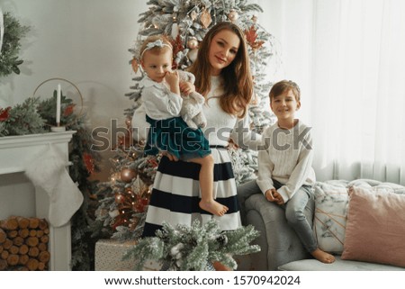 Beautiful family in Christmas time opening presents near the Christmas tree