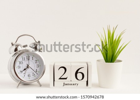 January 26 on a wooden calendar next to the alarm clock.Calendar date, holiday event or birthday
