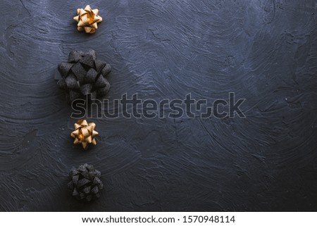 Gold and black bow for gift box on a black background. Christmas background.
