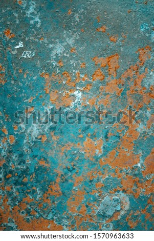 Vertical photo of a corroded old abandoned rusty sheet of iron with peeling cracked damaged blue paint. Trendy, modern, abstract, grunge, texture background.