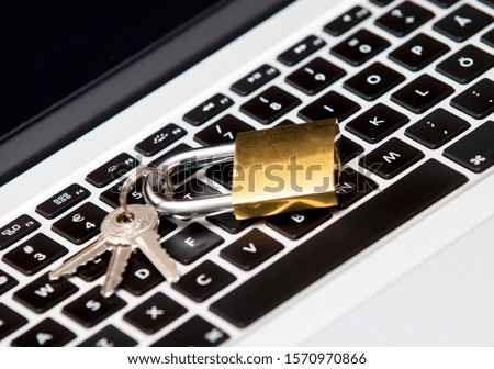 Cyber and information security concept image with a padlock on a laptop. Padlock locked with keys.