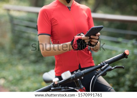 Riding on bike path,using smartphone while riding bike on sunny day