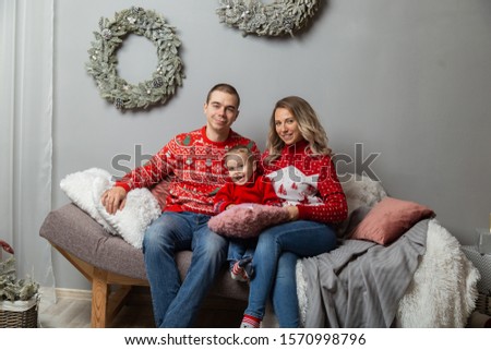 Beautiful happy family of three in a New Year's decor. Happy Merry Christmas 2020.