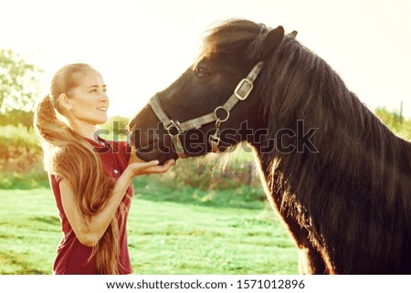 young beautiful girl stroking a horse on a Sunny day in the open vozduhonosnye