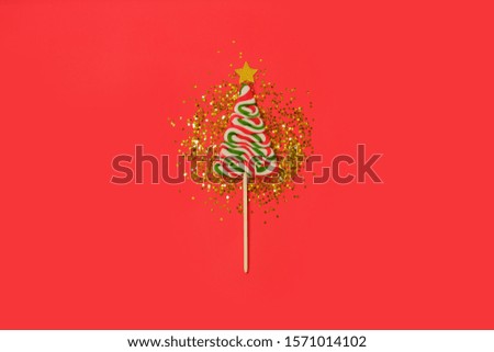 One christmas tree Candy on gold glitter stars on red background. Flat lay, top view. Festive decor, winter holidays theme.