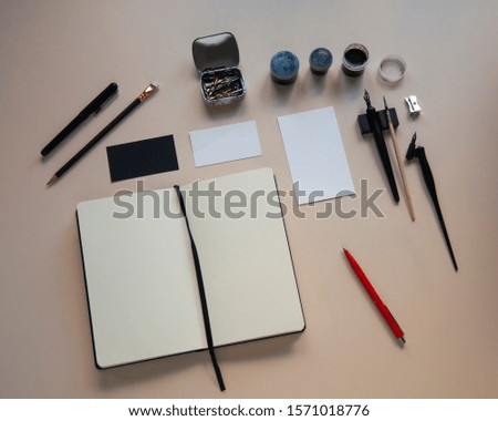 Opened white empty notebook and business card mockup. Drawing and writing instruments. Handwriting. Calligraphy 
 flat lay, top view, copy space.