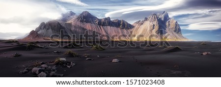 Vestrahorn mountaine on Stokksnes cape in Iceland during sunset. Amazing Iceland nature seascape. popular tourist attraction. Best famouse travel locations. Scenic Image of Iceland Royalty-Free Stock Photo #1571023408